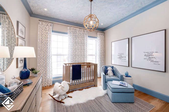 Modern blue and beige nursery with a baby blue swivel chair with dark blue piping.