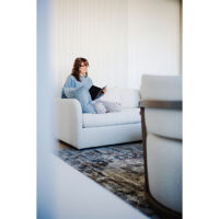 woman reading a book on in on a modern sofa