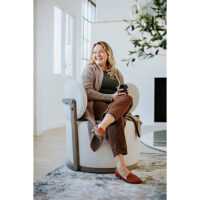 woman sitting in a custom swivel chair with exposed wood frame