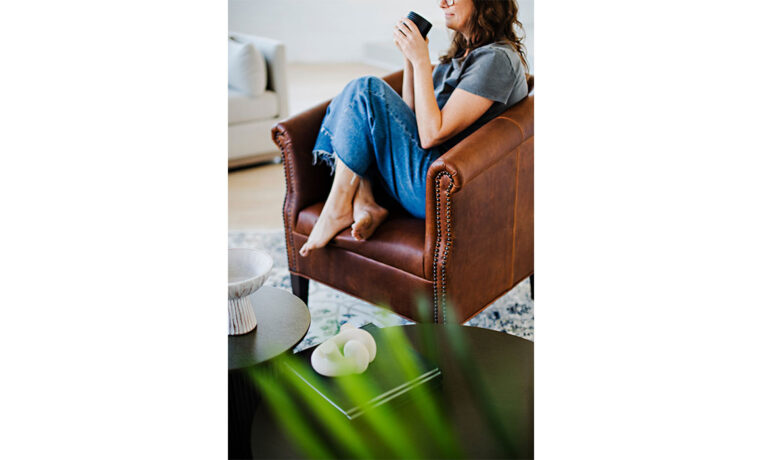 a detail shot of a custom lounge chair and a woman drinking coffee