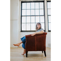 a woman relaxing in a custom lounge chair in a studio apartment