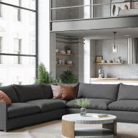 Bright studio apartment with large windows and large charcoal L-shaped sectional