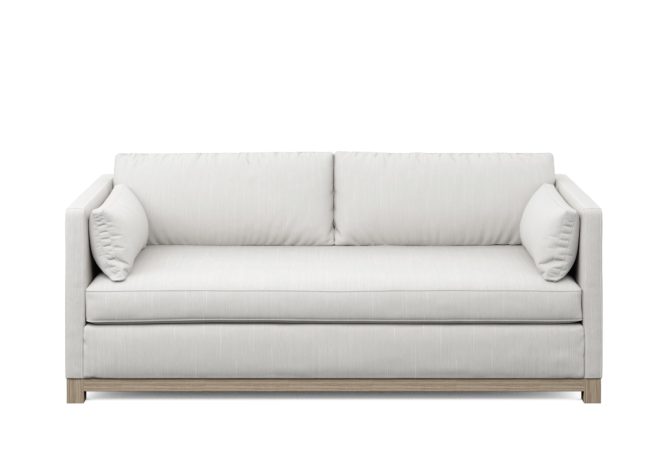 modern white condo sofa with wood base and two pillows