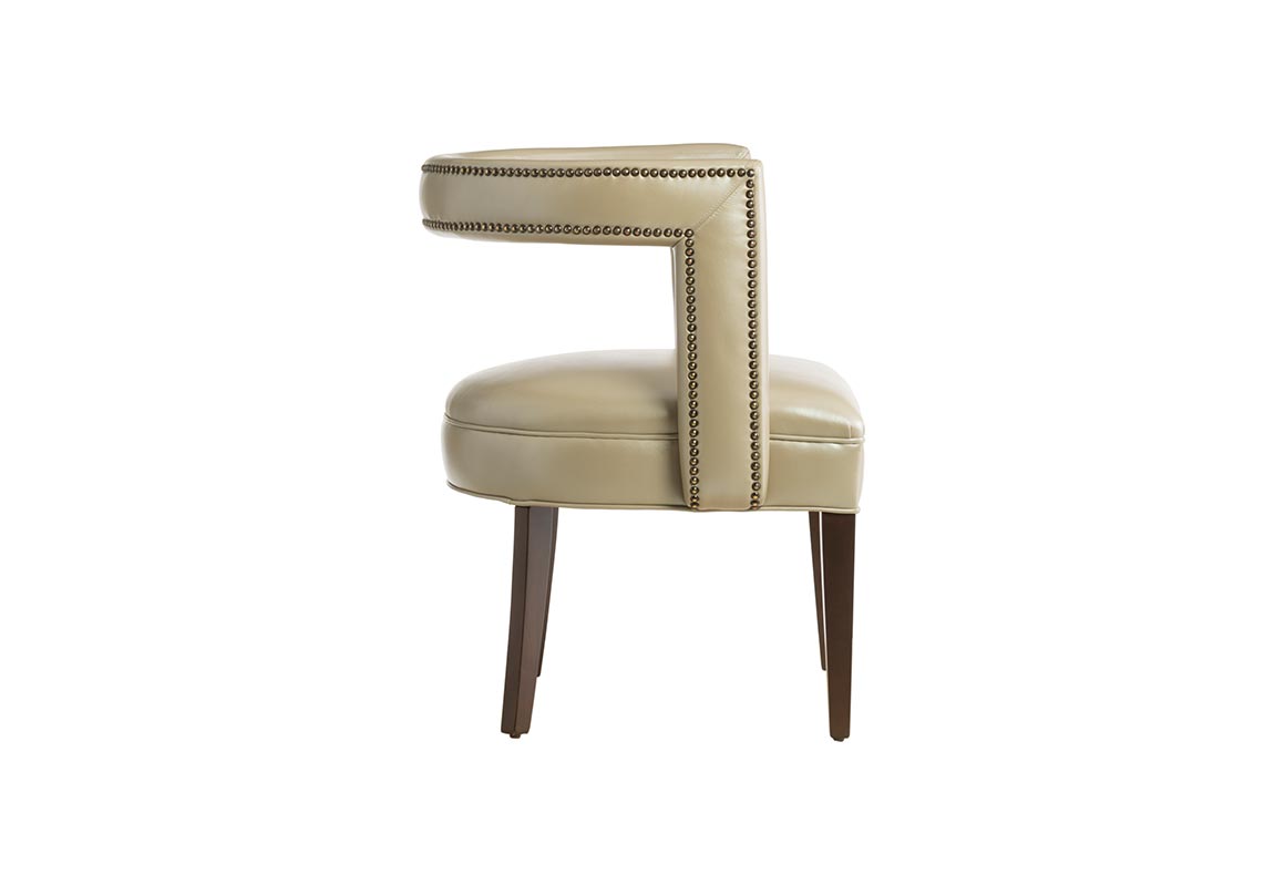 Side view of the 11182 Vogel chair in beige leather, but available in over 300 different fabrics, and showcased with nailhead trims and espresso wood finish.