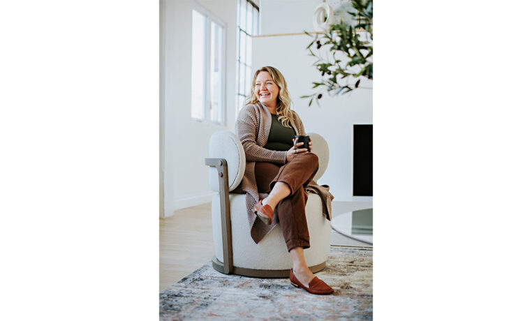woman sitting in a custom swivel chair with exposed wood frame