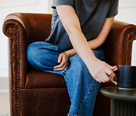 detail of nail head trim on an arm of a custom leather chair