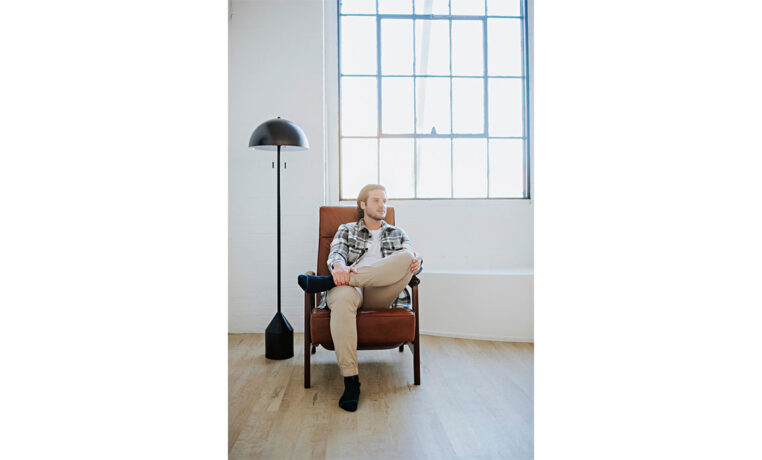 man relaxing in a custom brown recliner in a studio apartment