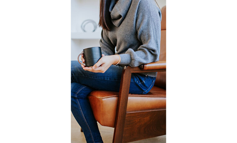 exposed wood arm detail with a woman in a brown leather recliner