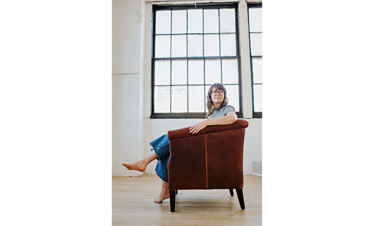 a woman relaxing in a custom lounge chair in a studio apartment