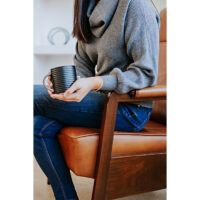 exposed wood arm detail with a woman in a brown leather recliner