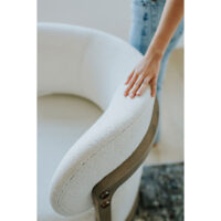 a detail shot of a white custom swivel chair with a curved back