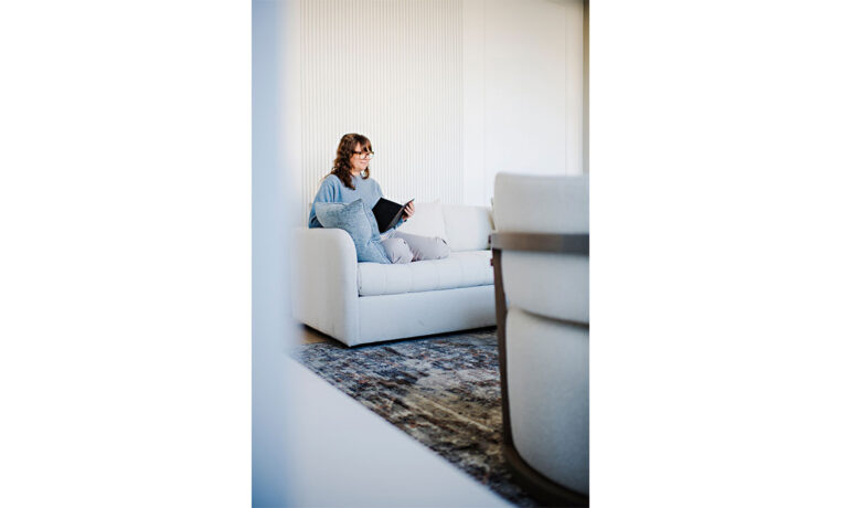 woman reading a book on in on a modern sofa
