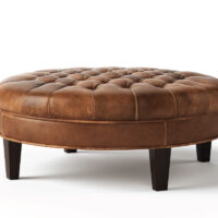 Round Cambridge tufted ottoman from Vogel by Chervin in brown leather and espresso legs with a hand-tufted top