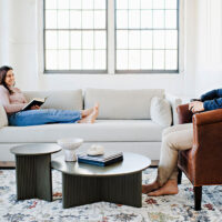 couple relaxing in a living room with one on a custom sofa and one sitting in a custom lounge chair