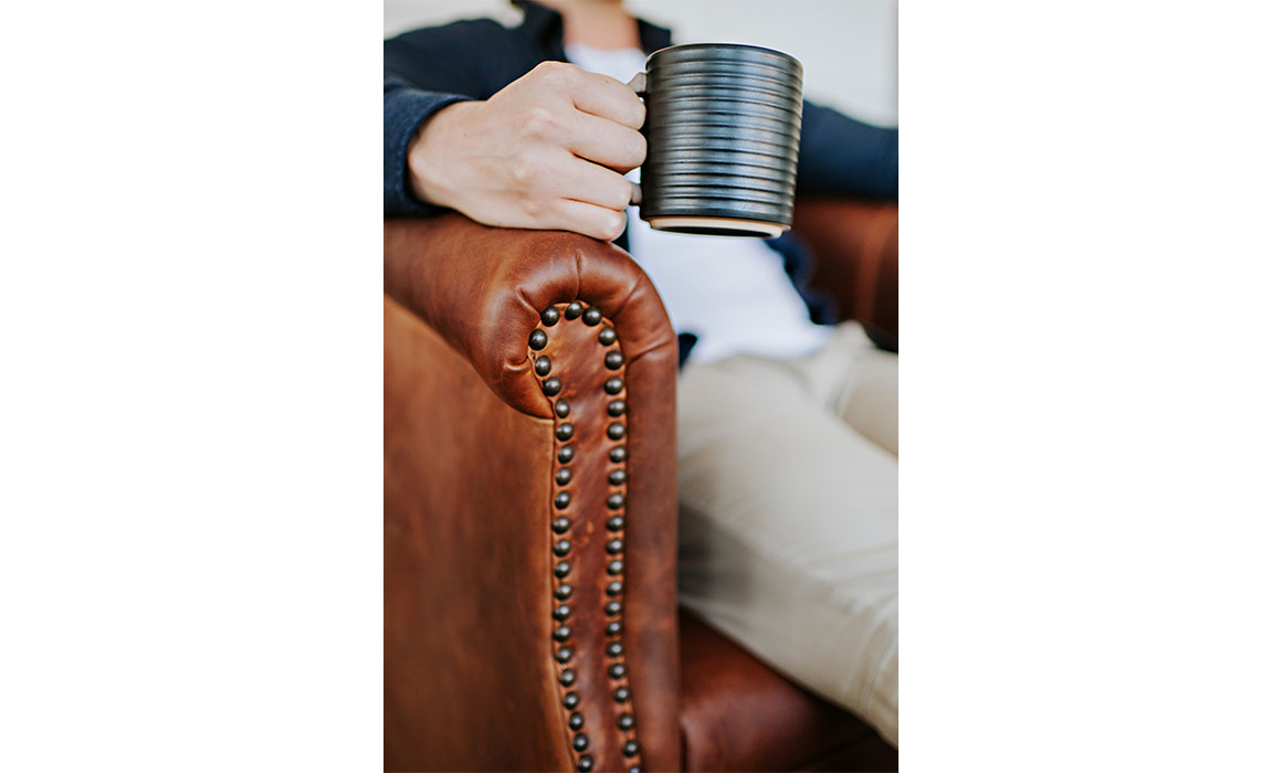 detail shot of a custom lounge chair with nail head trim on the arm