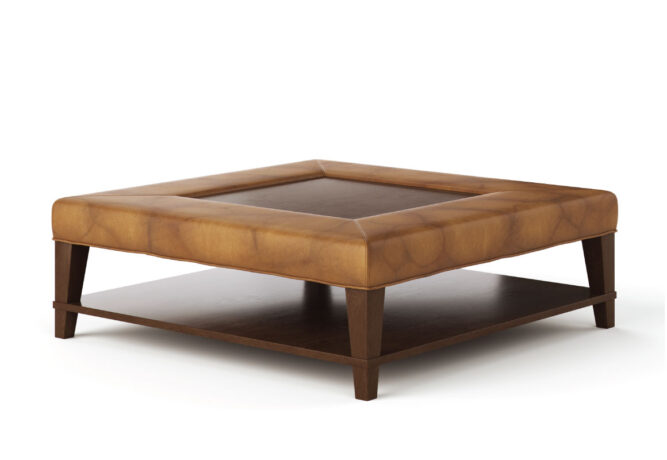 Angled shot of the traditional-style Kingston Ottoman made by Vogel in light brown leather with a wooden shelf and wood accents